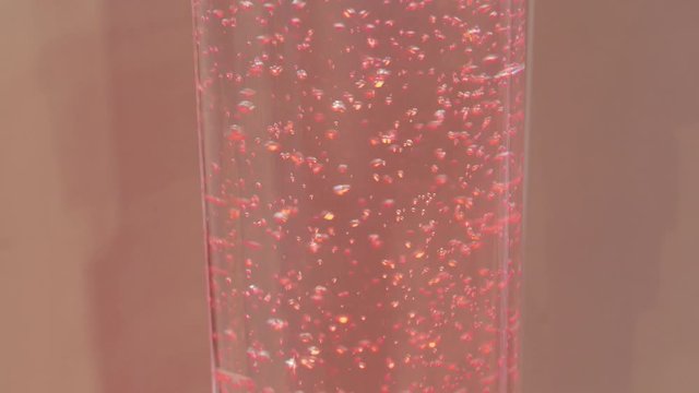 Water with air bubbles level rising in glass tube, transparent clear red liquids in pipe, two shots. Color illumined fluid growing under increasing pressure in glass-lined tube. Flow control system