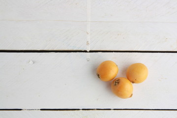 delicious yellow medlar fruit with wooden background