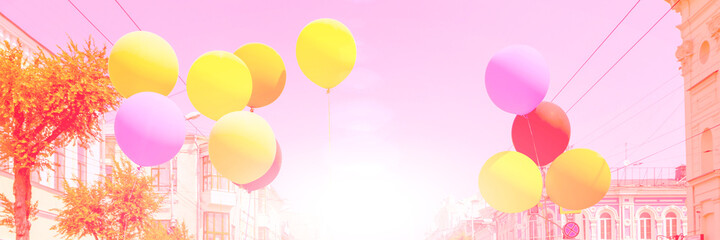 Multi-colored balloons on a background of urban buildings.