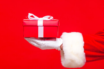 christmas Photo of Santa Claus gloved hand with red giftbox