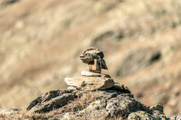 Beautiful close up of a small cairn high up on a mountain with a blurry bokeh background
