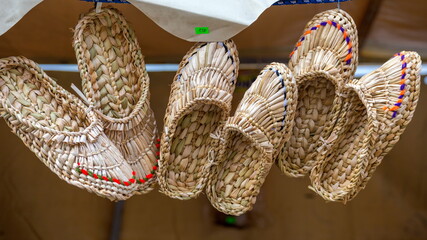 Russian folk art. Wicker bast shoes on sale exhibition.