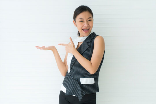 Asian beautiful young woman smile presenting with one hand on upper right side empty and left hand pointing. looking at camera in studio Isolated on white background. Advertisement& presentation conce