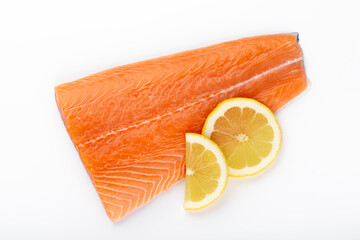 Fresh raw salmon fillets with herbs and lemon isolated on white background.