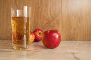  Juice and red apples on a marble table. Healthy eating Bubbles in a glass with juice.