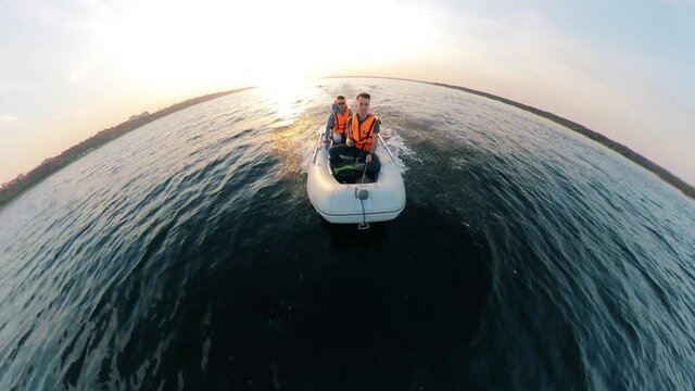 Half-circle view of two men navigating the motorboat