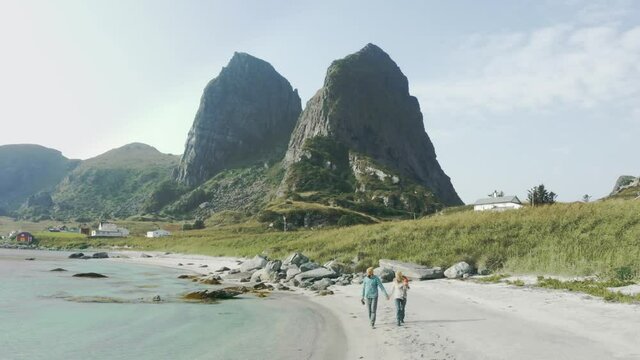 Family with baby walking on beach traveling at sea active healthy lifestyle summer vacations couple with child outdoor in Norway 