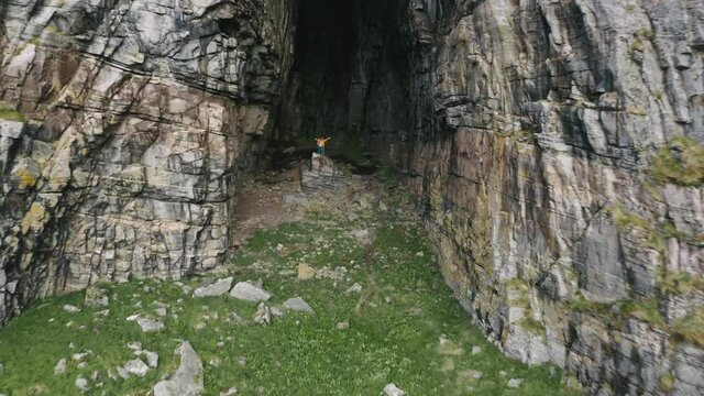 Travel couple family with baby in cave vacations outdoor active lifestyle in Norway mountains aerial drone view grotto Kirkhelleren hole in rock