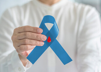 Diabetes Awareness ribbon for World diabetes day with red blood drop on blue bow color in person...