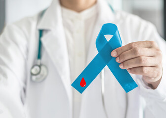 Diabetes Awareness ribbon for World diabetes day with red blood drop on blue bow color in doctor...