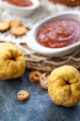 Quince Close up with a jelly quince in a white crockery containers and little toasts to spread.