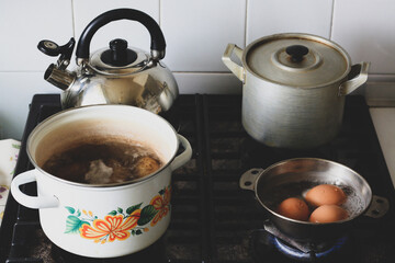 Stove in the kitchen, it has a kettle, a saucepan, boiled potatoes and eggs