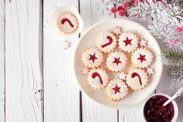 Christmas holiday Linzer cookies. Top view on a marble plate against a white wood background with copy space.