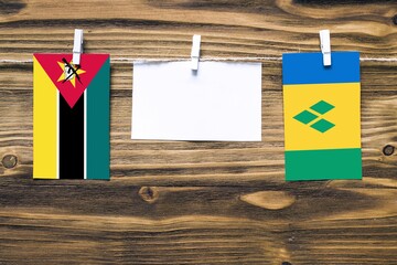 Hanging flags of Mozambique and Saint Vincent And The Grenadines attached to rope with clothes pins...