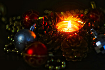 Attributes creating a New Year and Christmas mood. A basket glued from pine cones and a candle burning in its center.