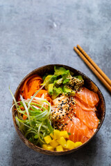 Hawaiian poke bowl with raw salmon, pickled carrots, mango and avocado