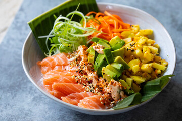 Hawaiian poke bowl with raw salmon, pickled carrots, mango and avocado