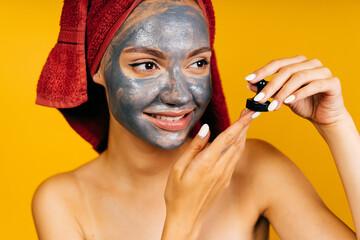 beauty salon client with black mask on her face