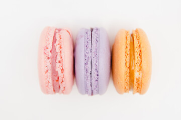 Colorful pink, orange, purple cake macaron or macaroon on white isolated background, top view