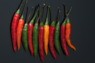  chili peppers on a dark mirror background
