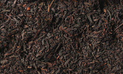 Dry black tea leaves background and texture
