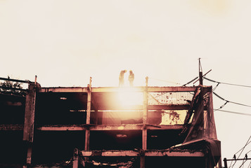 Fototapeta na wymiar Silhouette City worker, construction crews to work on high ground heavy industry and safety concept over blurred natural background sunset 