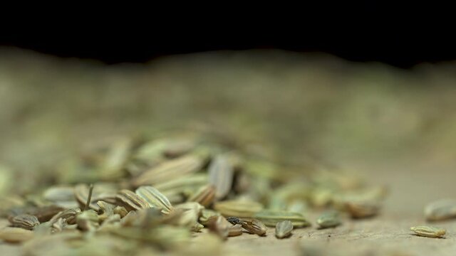 Light passes over Caraway seeds isolated in dimly lit room