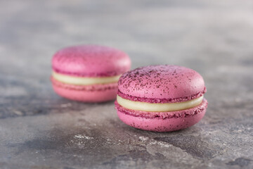 two macarons on a gray table. Flash photo. Space for text. Gorizontal. Splash