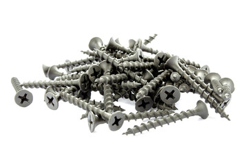 Black screws isolated on white. Pile of new black screws isolated on a white background. Steel screws, iron screws on wood close-up. Fixing screws for construction on a white background.