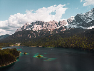 Aerial panorama of azure blue Bavarian Eibsee lake with panorama of snow-covered Zugspitze on a perfect summer day (Bavaria, Germany, Europe)