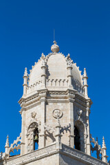 Fototapeta na wymiar Close-up of the historic Mosteiro dos Jeronimos' (Jeronimos Monastery) bell tower in Belem, Lisbon, Portugal, on a sunny day.