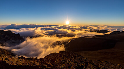 Fototapeta na wymiar Sunrise on a mountain top over a sea of clouds, Haleakala, Maui, Hawaii
