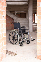 Fototapeta na wymiar An isolated wheelchair in a house under construction behind a door