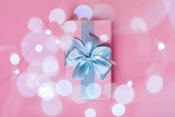 Gift box with Blue ribbon on Pink background for copy space. Christmas minimal concept idea.