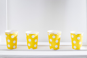 the yellow polka dot paper cups on white shelf in the kitchen cabinet