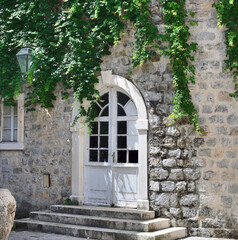 Fototapeta na wymiar Door in a stone house with twisted plush in Old Town in Budva, Montenegro