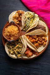Mexican stew tacos also called "guisados" with rice on dark  background
