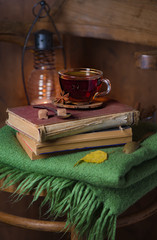 Fototapeta na wymiar tea, book and plaid on a wooden chairHome interior vintage decor