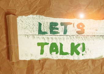 Conceptual hand writing showing Let S Is Talk. Concept meaning suggesting in the beginning of a conversation on the topic Cardboard which is torn placed above a wooden classic table