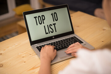 Writing note showing Top 10 List. Business concept for the ten most important or successful items in a particular list woman with laptop smartphone and office supplies technology