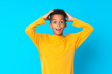 African American boy over isolated blue background with surprise and shocked facial expression