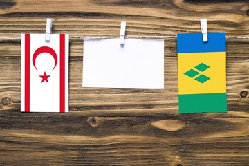 Hanging flags of Northern Cyprus and Saint Vincent And The Grenadines attached to rope with clothes...