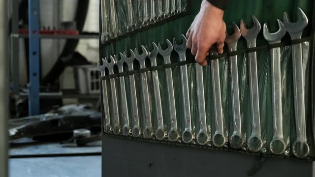 A set of tools for repair in car service - mechanic's hands, close up