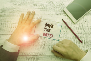 Fototapeta premium Conceptual hand writing showing Save The Date. Concept meaning Organizing events well make day special event organizers Hand hold note paper near writing equipment and smartphone