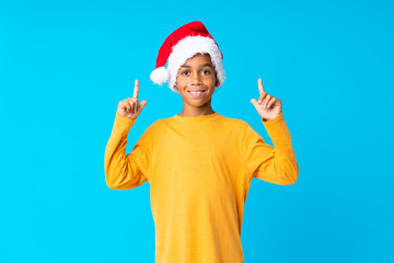 Fototapeta na wymiar African American boy with christmas hat pointing up a great idea