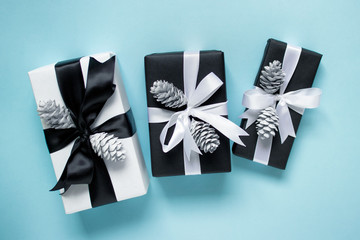 Three gift boxes with satin bows and white pine cones