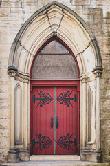 red ornate church door with iron accents