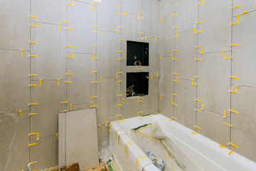 Construction work installing ceramic tile on reconstruction of bathroom
