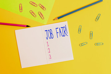 Writing note showing Job Fair. Business concept for event in which employers recruiters give information to employees Blank squared notebook pencils markers paper sheet colored background