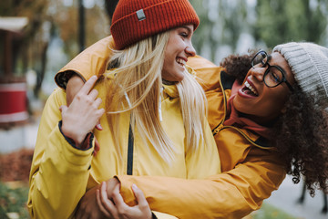 Two pretty women having fun and walking in park